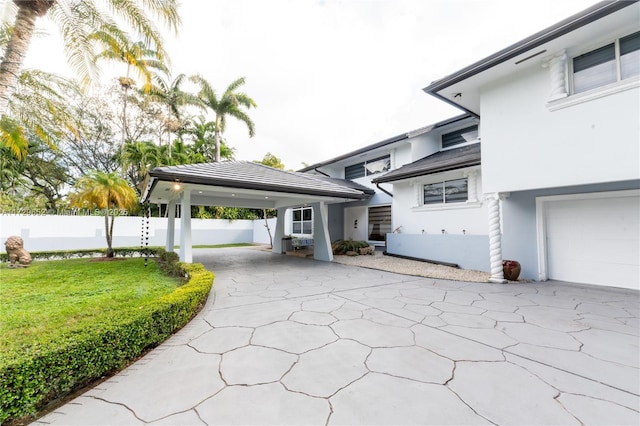 view of property exterior featuring a yard, a garage, and a carport