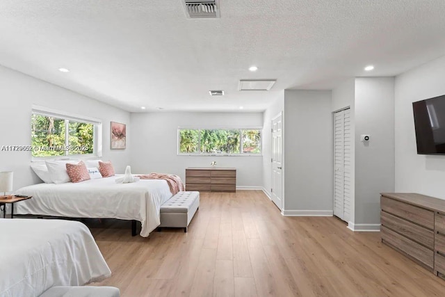 bedroom featuring a textured ceiling and light wood-type flooring