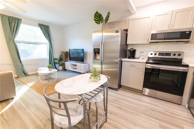 kitchen with white cabinetry, backsplash, light hardwood / wood-style floors, and appliances with stainless steel finishes