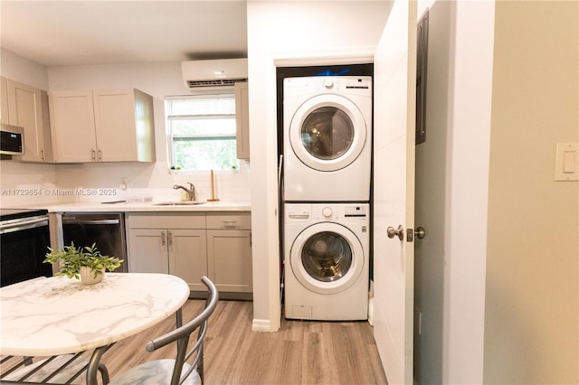 laundry room with an AC wall unit, stacked washer / drying machine, sink, and light wood-type flooring