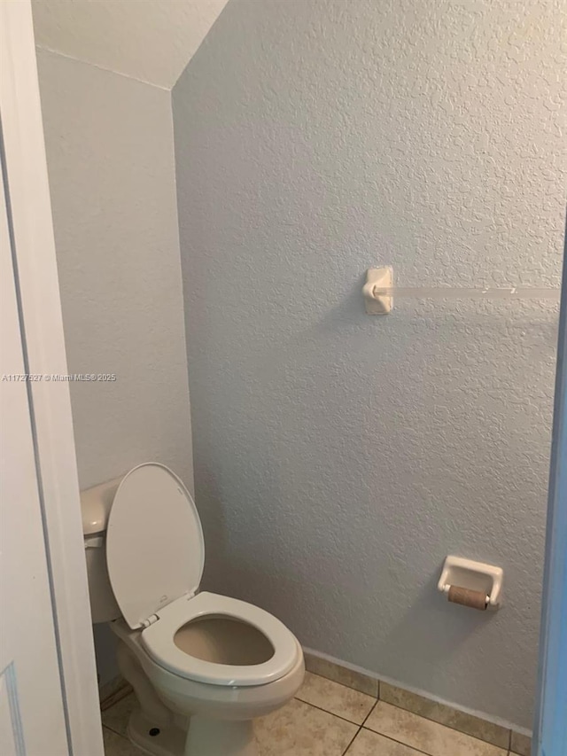 bathroom featuring toilet and tile patterned flooring