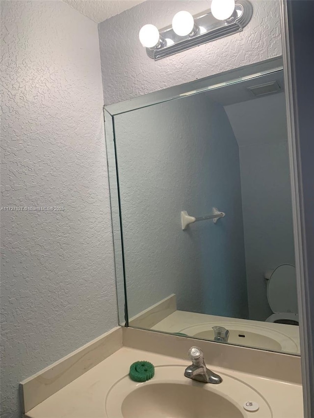 bathroom featuring a textured ceiling and vanity