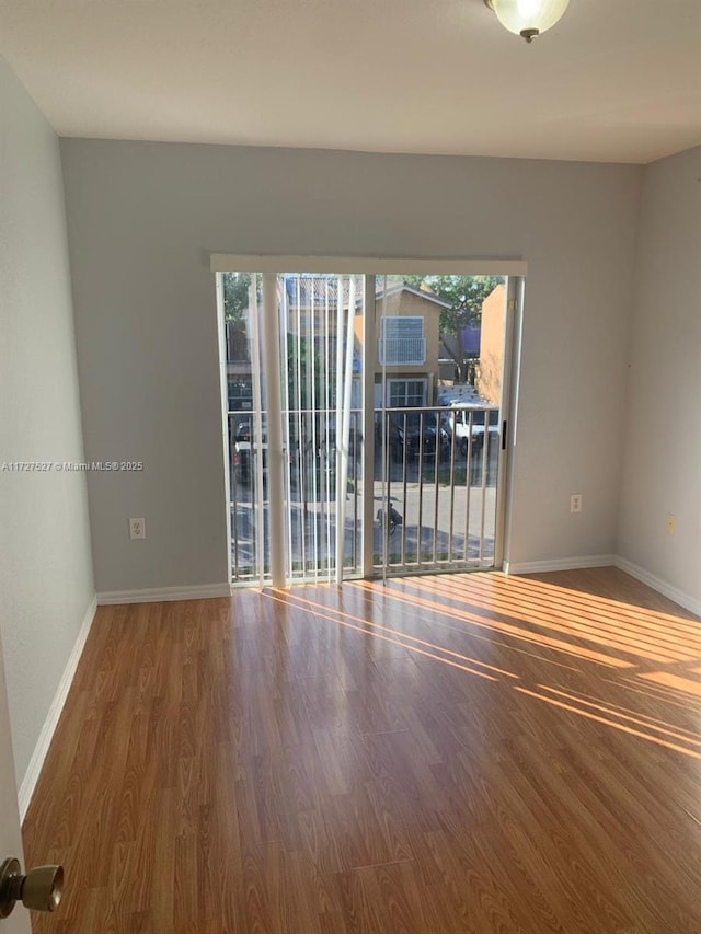 unfurnished room with hardwood / wood-style floors