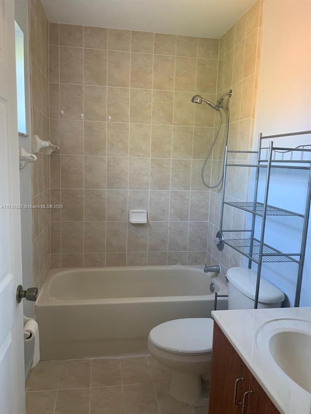 full bathroom featuring toilet, vanity, tiled shower / bath, and tile patterned flooring