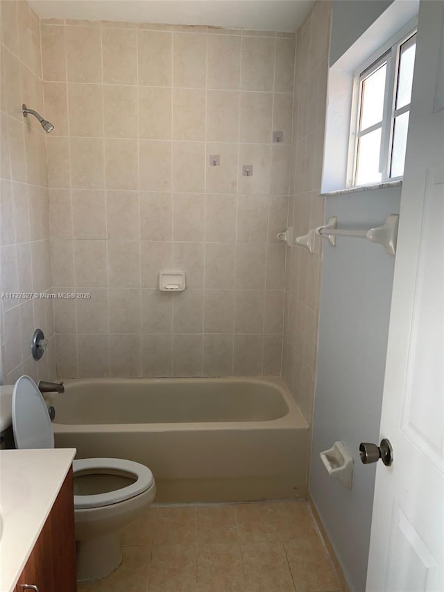 full bathroom with toilet, vanity, tiled shower / bath, and tile patterned flooring