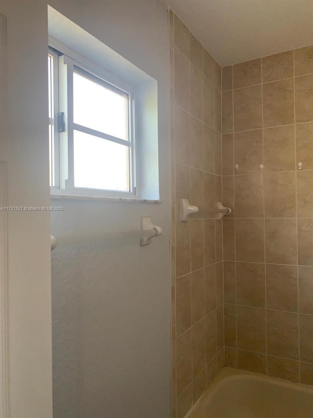 bathroom featuring tiled shower / bath