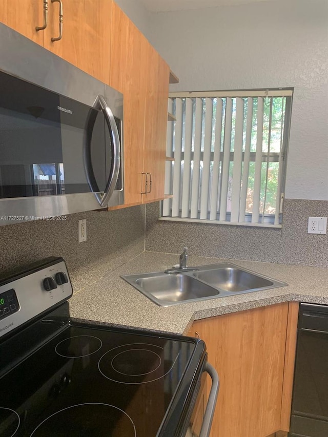 kitchen with appliances with stainless steel finishes, backsplash, and sink