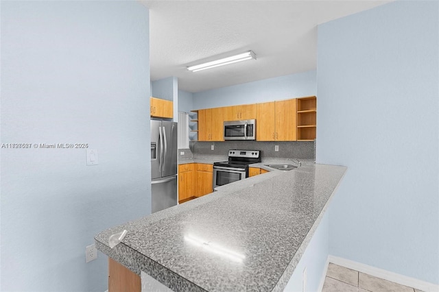 kitchen featuring kitchen peninsula, decorative backsplash, sink, light tile patterned flooring, and stainless steel appliances