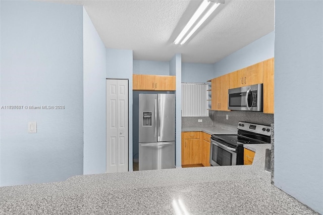 kitchen with tasteful backsplash, stainless steel appliances, and a textured ceiling