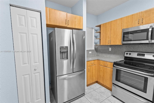 kitchen featuring backsplash, stainless steel appliances, and light tile patterned flooring