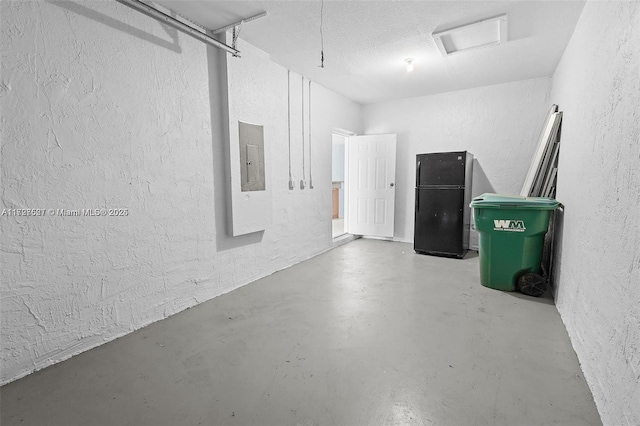 garage with electric panel and black fridge