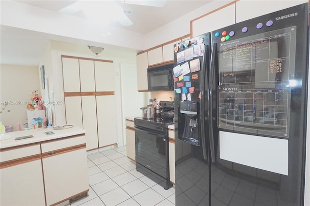 kitchen with white cabinetry, light tile patterned floors, and black appliances