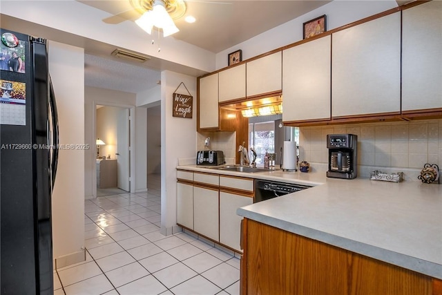 kitchen featuring light tile patterned flooring, white cabinetry, sink, backsplash, and black appliances