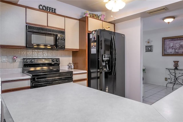 kitchen featuring backsplash, tile patterned flooring, and black appliances