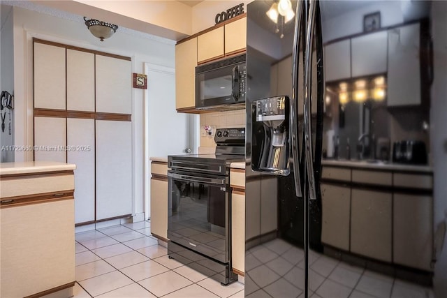 kitchen with tasteful backsplash, cream cabinetry, light tile patterned floors, and black appliances