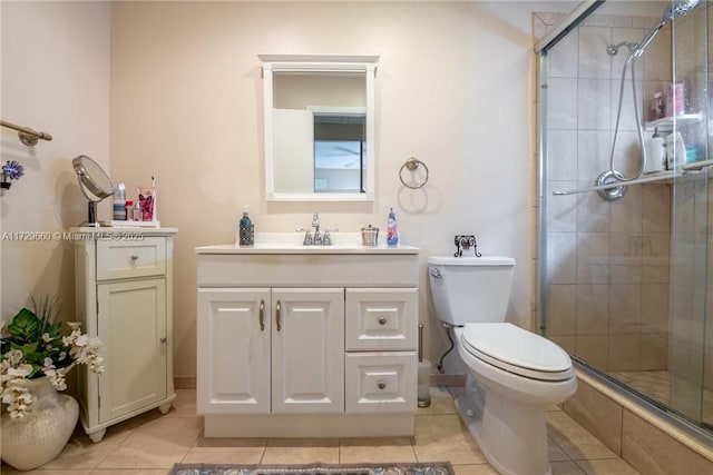 bathroom with vanity, toilet, tile patterned floors, and a shower with shower door