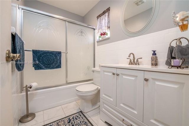 full bathroom with toilet, combined bath / shower with glass door, tile walls, vanity, and tile patterned flooring