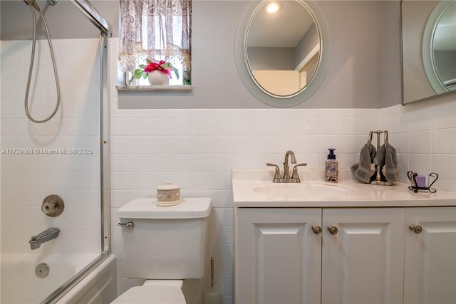 full bathroom featuring vanity, bath / shower combo with glass door, and toilet