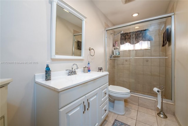 bathroom with vanity, a shower with door, tile patterned floors, and toilet