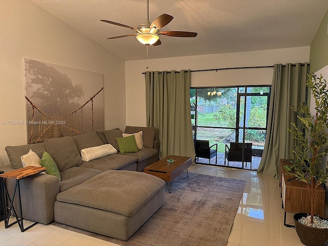 living room featuring ceiling fan, a textured ceiling, light tile patterned floors, and vaulted ceiling