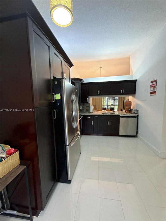 kitchen featuring light tile patterned flooring, sink, stainless steel refrigerator, dishwashing machine, and backsplash