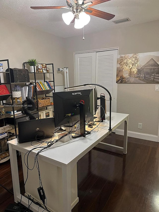 office area with dark hardwood / wood-style flooring, ceiling fan, and a textured ceiling