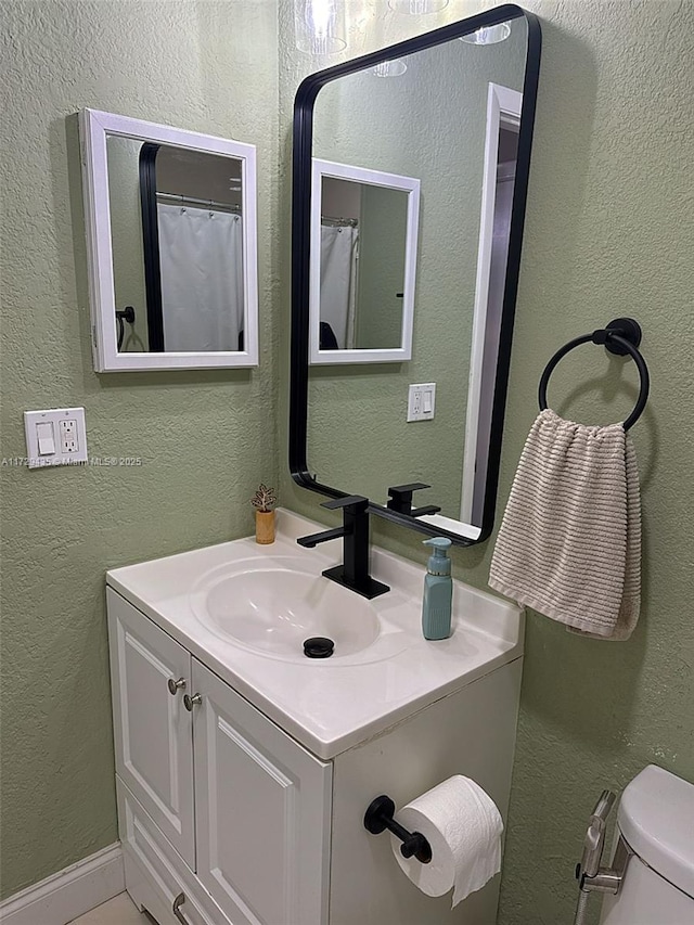 bathroom featuring vanity and toilet