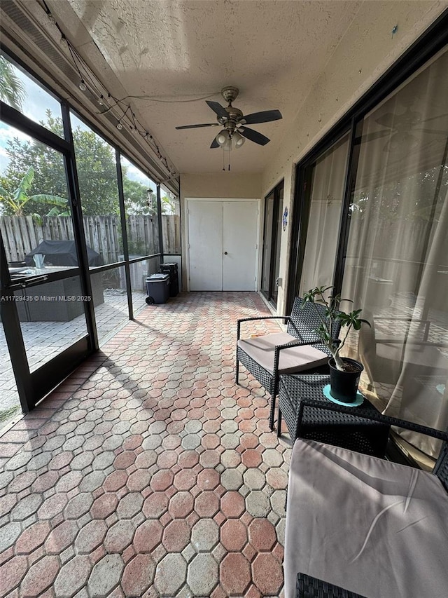 sunroom / solarium featuring ceiling fan