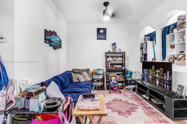 living room with ceiling fan and decorative columns