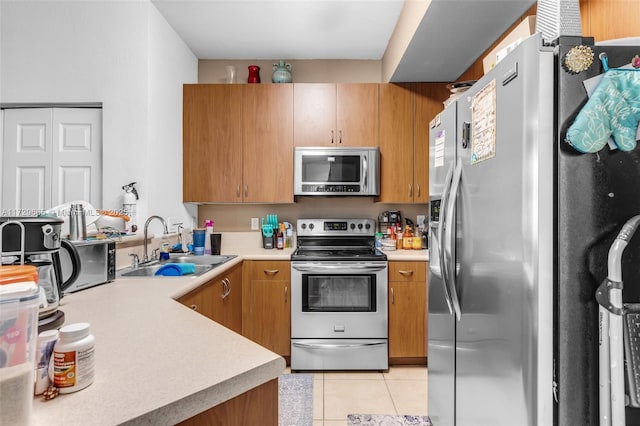 kitchen featuring sink, appliances with stainless steel finishes, and light tile patterned flooring