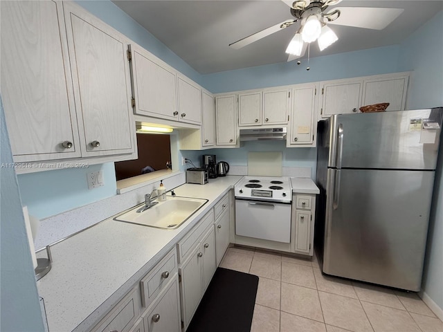 kitchen featuring sink, stainless steel fridge, oven, ceiling fan, and light tile patterned floors