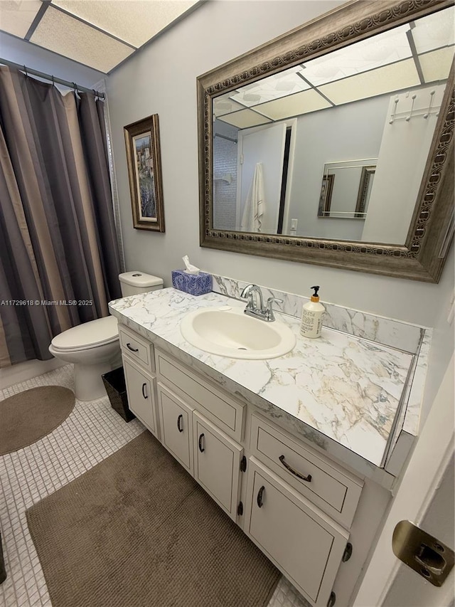 bathroom with toilet, tile patterned flooring, and vanity