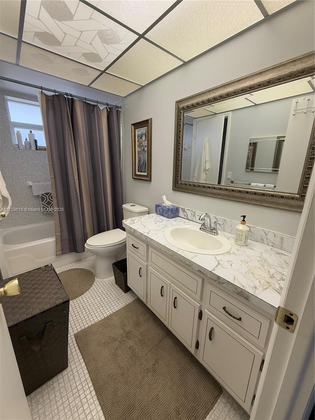 full bathroom with toilet, shower / tub combo with curtain, tile patterned flooring, a drop ceiling, and vanity