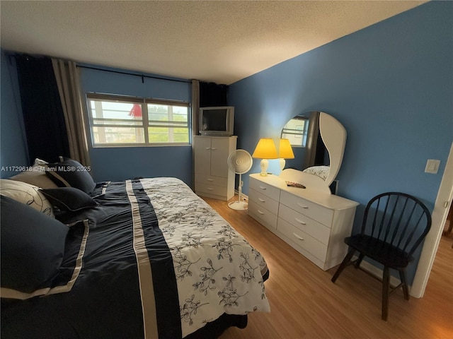 bedroom featuring light wood-type flooring and a textured ceiling