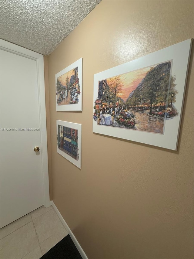 hallway with light tile patterned flooring and a textured ceiling