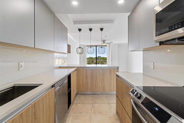 kitchen with ceiling fan, pendant lighting, decorative backsplash, light tile patterned flooring, and appliances with stainless steel finishes