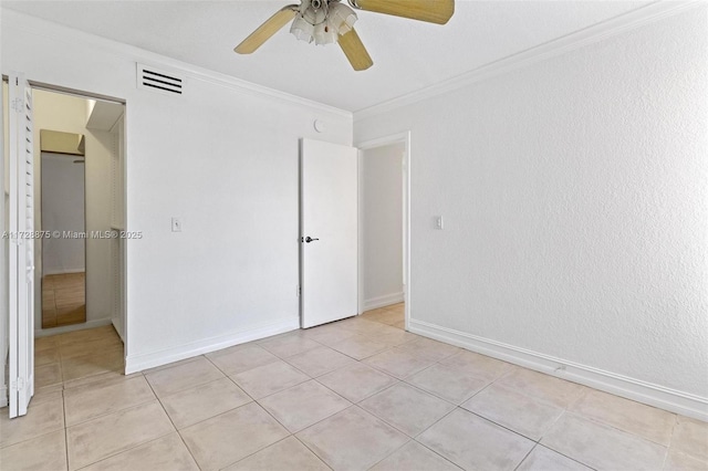 unfurnished bedroom featuring ceiling fan, light tile patterned flooring, crown molding, and a closet