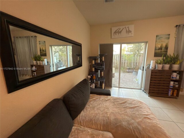 tiled bedroom featuring vaulted ceiling and access to outside