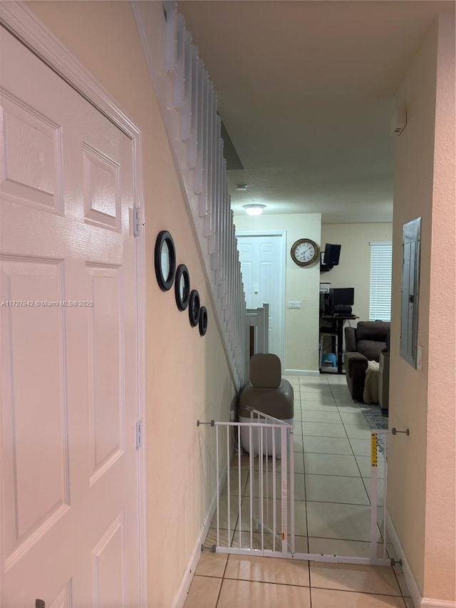 corridor with electric panel and light tile patterned floors