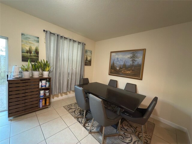 dining room featuring a textured ceiling and light tile patterned flooring