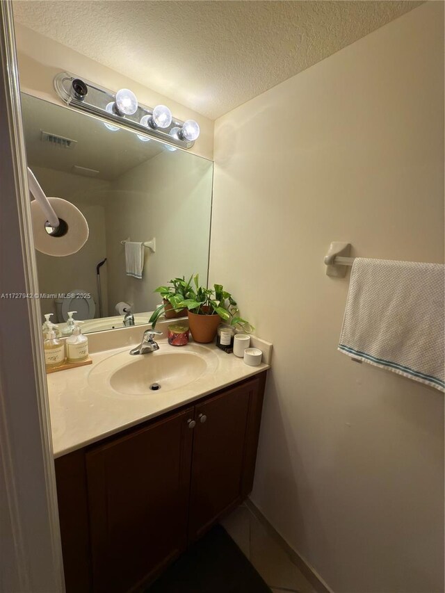 bathroom with vanity and a textured ceiling