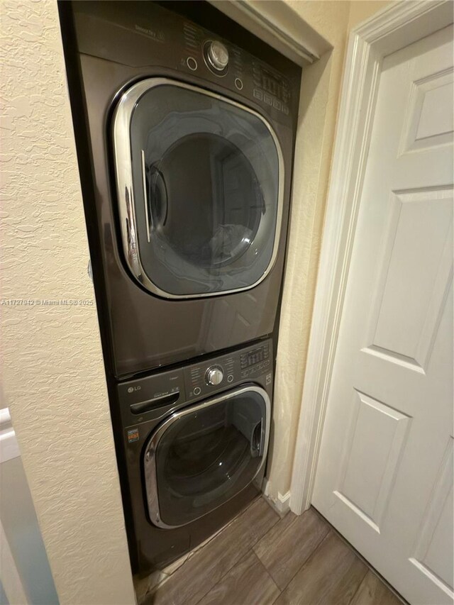 washroom featuring stacked washer and dryer and hardwood / wood-style floors