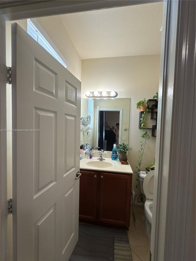 bathroom featuring tile patterned floors, vanity, and toilet