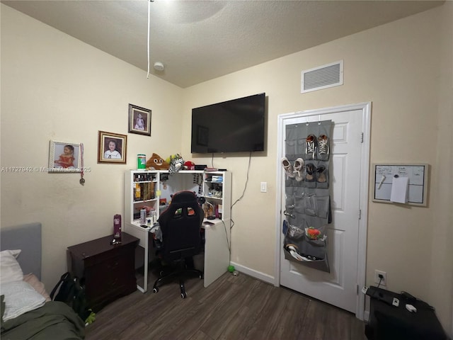 bedroom with dark wood-type flooring and a textured ceiling