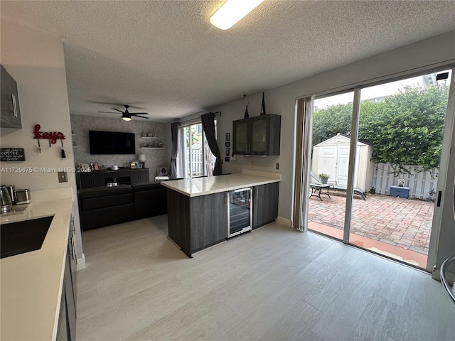 kitchen with plenty of natural light, sink, beverage cooler, and kitchen peninsula