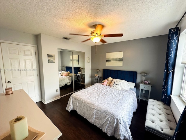 bedroom featuring ceiling fan, dark wood-type flooring, a textured ceiling, and a closet