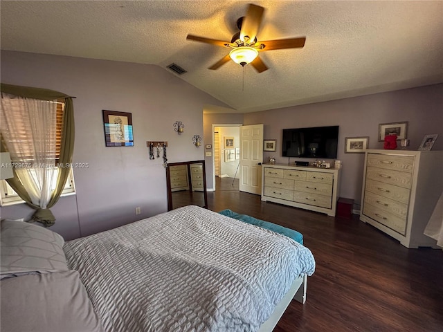 bedroom featuring ceiling fan, dark wood-type flooring, a textured ceiling, and lofted ceiling