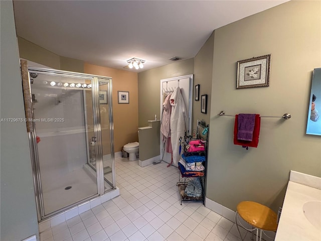 bathroom featuring toilet, an enclosed shower, tile patterned floors, and vanity