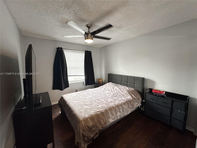 bedroom with ceiling fan, dark wood-type flooring, and a textured ceiling