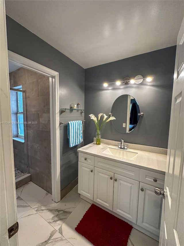 bathroom with a shower with door and vanity